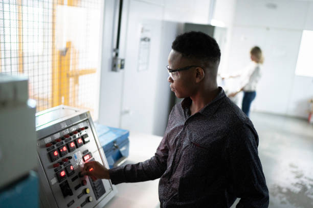 Young man using machine in industry