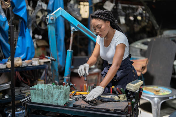 Mechanical girl wearing half overall hold screw driver stay focus concentrate on tighten screw ar at garage car repair shop