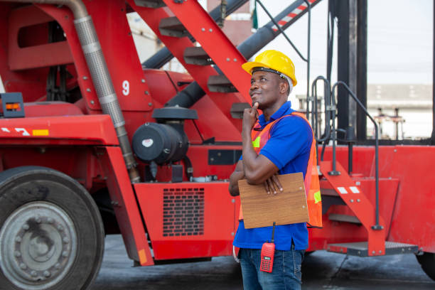 Portrait of happy man at cargo container. Young worker man with doc in the construction container yard