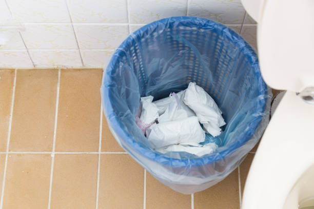 Used sanitary napkin pad wrapped and disposed in rubbish bin in toilet