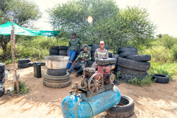 african man entrepreneur fixing tires on the side of the road