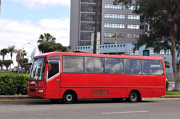 A old red bus parked next to a park