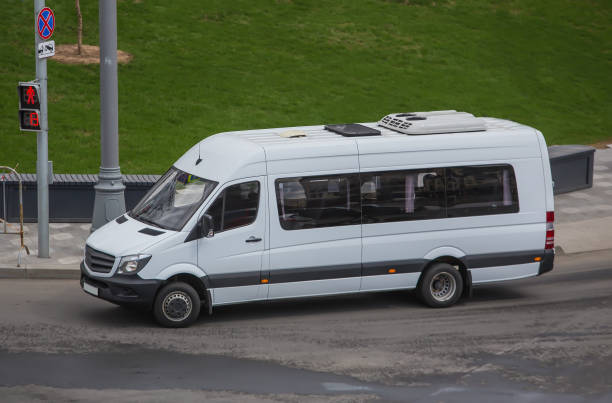 Minibus moves down the street in the city in the spring