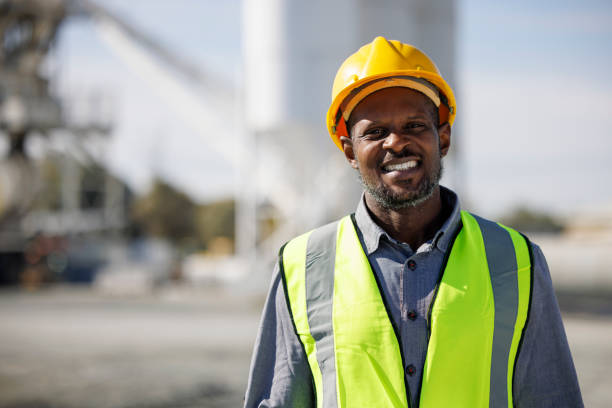 Portrait of smiling engineer with hardhat at construction site